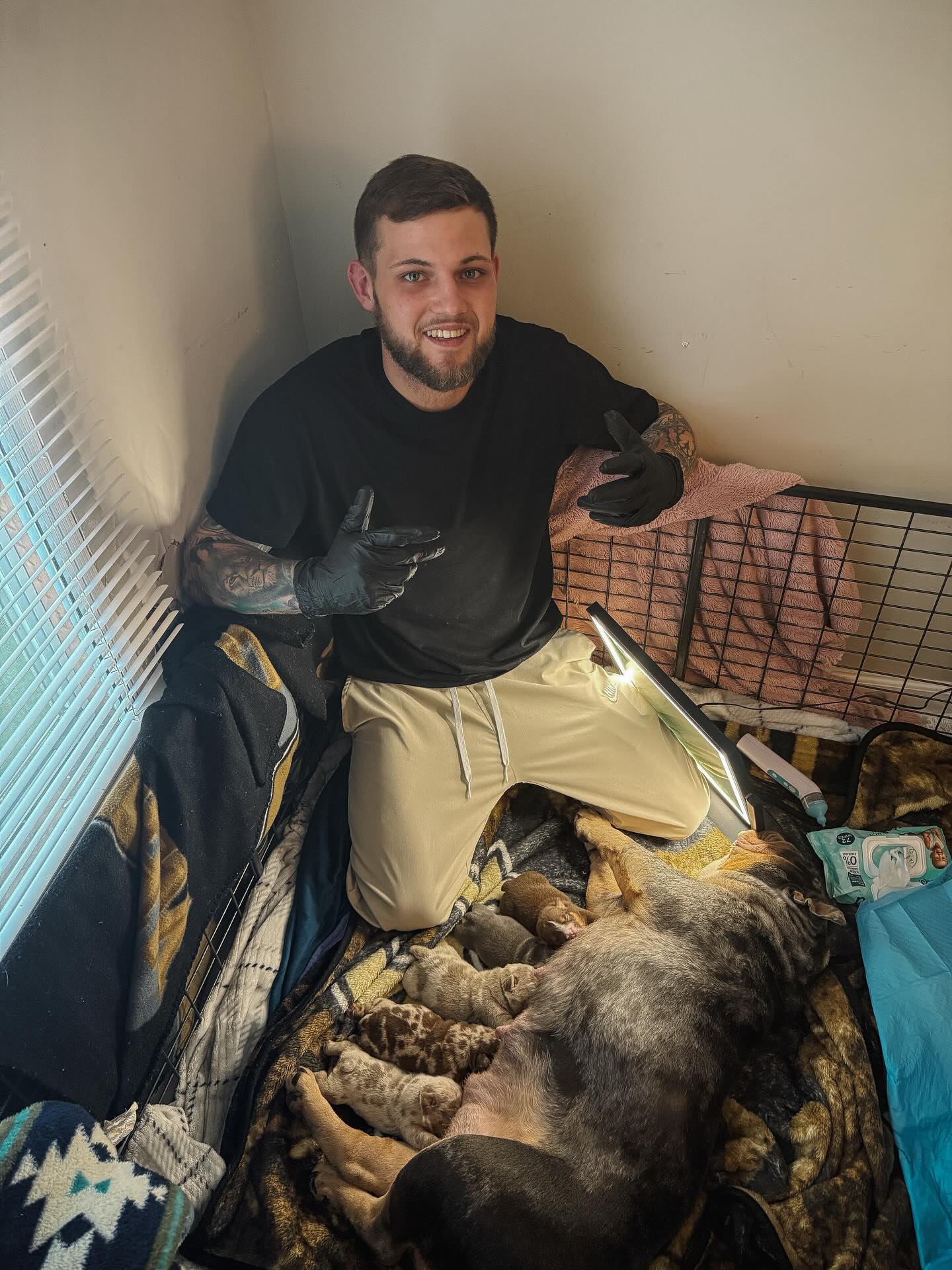 Logan Folse in the whelping room with PHAT MA and her nursing litter